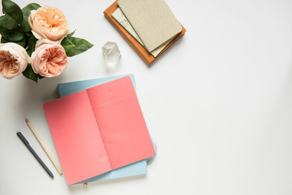 A variety of notebooks in different sizes arranged on a wooden desk, showcasing A4, B5, king size, and compact options.