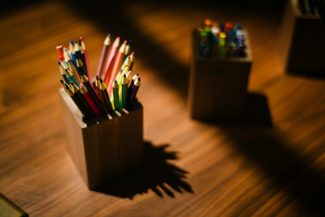 Wooden box filled with colorful pencils on a table